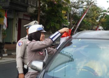 Aksi Simpatik Satlantas Polres Malang di Semarak HUT RI ke – 81, Bagikan Bendara Merah Putih Kepada Warga Yang Melintas